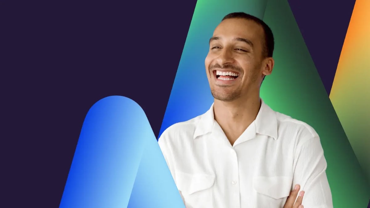 A laughing man with short hair wearing a white shirt, framed by large 3D shapes in blue, green, and orange gradient hues on a dark background.